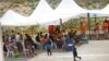 Migrantes centroamericanos, entre ellos menores de edad, que fueron expulsados de EE. UU. en base al Título 42 esperan bajo un toldo en el Instituto Nacional para la Migración en Ciudad Juárez, México el 17 de agosto de 2021. 