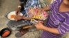 Un niño pobre venezolano conocido como "Scooby" disfruta las golosinas donadas que le lleva Freddy Paz. Foto de Gustavo Ocando, VOA.