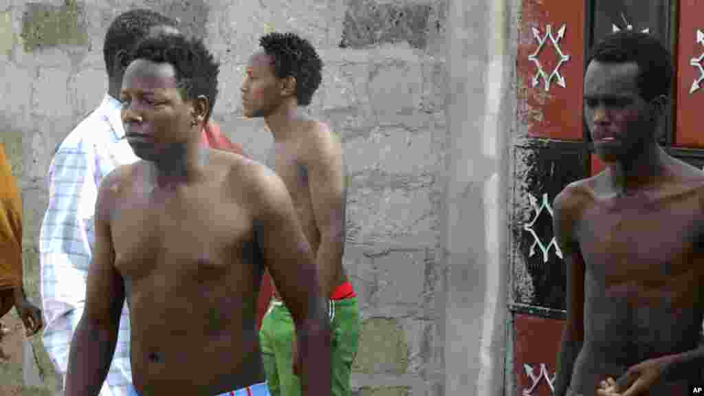 Torses nues, des étudiants sortent d'une maison où ils ont cherché refuge après avoir échappé à une attaque des hommes armés à Garissa, au Kenya, jeudi 2 Avril, 2015