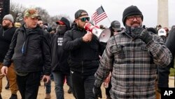 Los miembros de Proud Boys, incluidos Zachary Rehl, izquierda, Ethan Nordean, centro, y Joseph Biggs, caminan hacia el Capitolio de Estados Unidos en Washington, en apoyo al presidente Donald Trump, el 6 de enero de 2021.