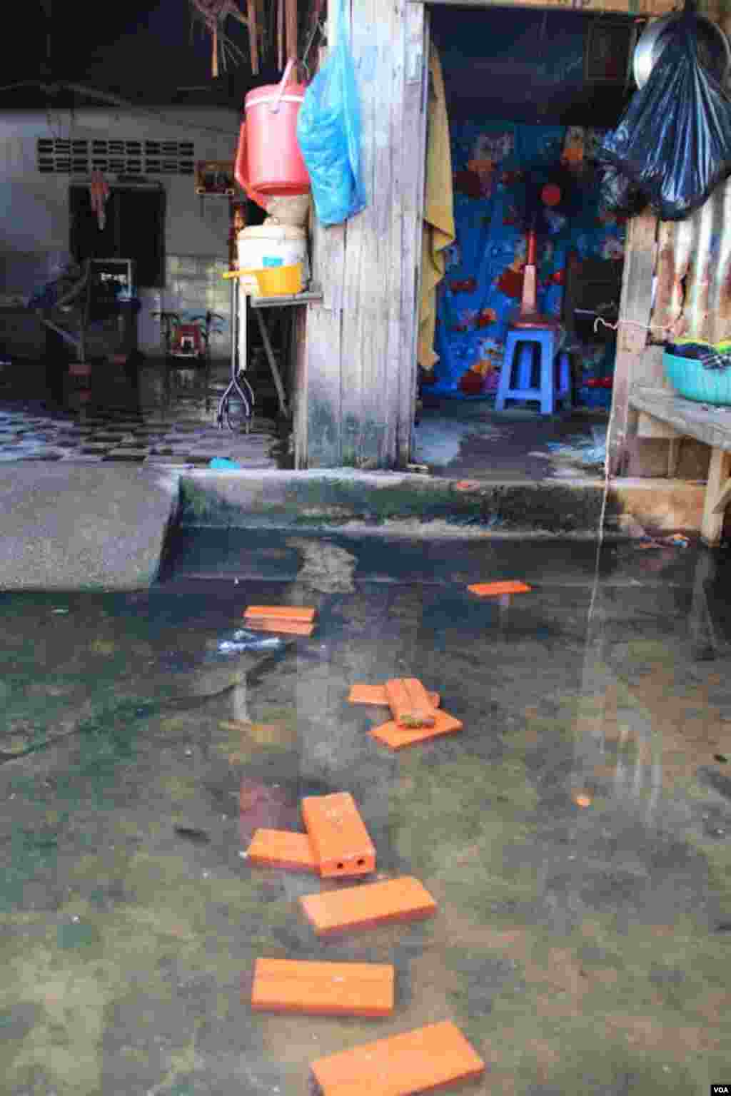 The flood water from the rain is still there in front of Khoeun Sovat’s house in Boeung Kak community in Phnom Penh, Cambodia, Nov. 13, 2014. (Nov Povleakhena/VOA Khmer)