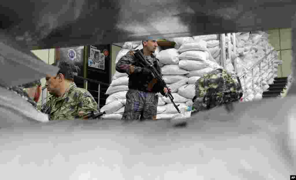Pro-Russian fighters guard their military unit in the city of Donetsk, eastern Ukraine, June 27, 2014.