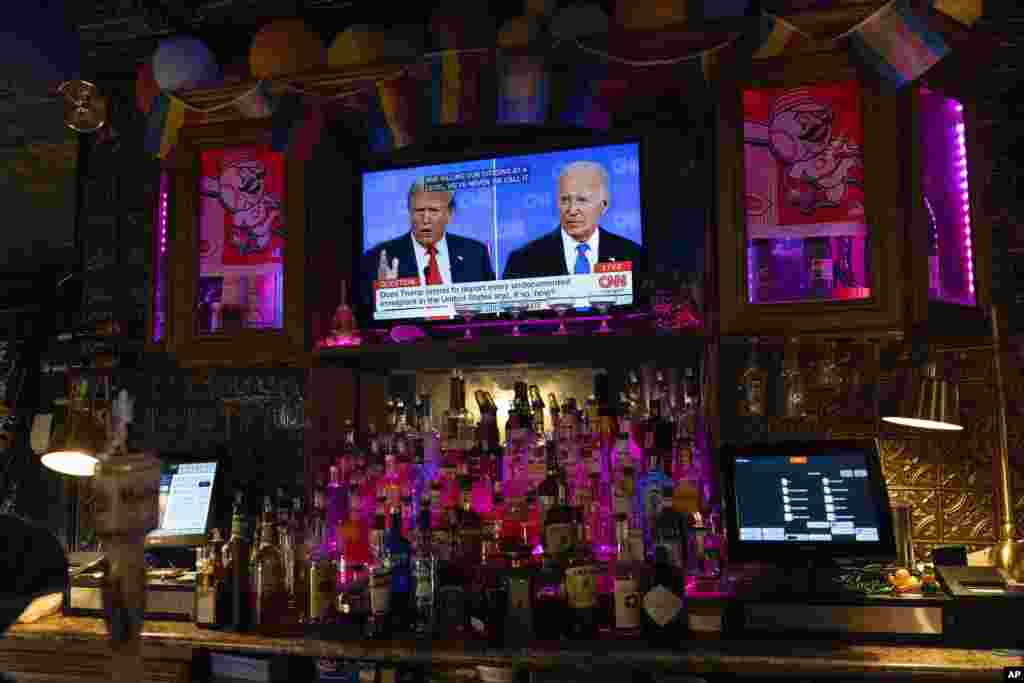 លោកប្រធានាធិបតី Joe Biden(ស្តាំ) និងបេក្ខជនប្រធានាធិបតីនៃបក្សសាធារណរដ្ឋលោក Donald Trump (ឆ្វេង) ត្រូវបានឃើញនៅលើកញ្ចក់ទូរទស្សន៍មួយអំឡុងការជជែកដេញដោលប្រធានាធិបតីកាលពីថ្ងៃទី២៧ មិថុនា ឆ្នាំ២០២៤។(AP Photo/Carolyn Kaster)
