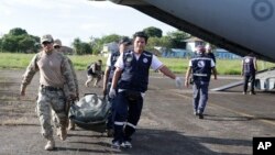 Soldiers and health brigade members carry equipment from a plane to be used in areas affected by an earthquake in Yurimaguas, Peru, May 26, 2019