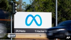 Un automóvil pasa frente al nuevo logotipo Meta de Facebook en un letrero en la sede de la compañía el 28 de octubre de 2021, en Menlo Park, California.
