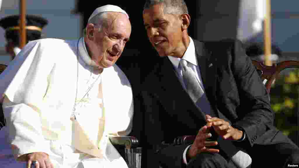 Le président américain Barack Obama parle à l’oreille du pape François lors de la visite du souverain pontife à la Maison Blanche, Washington, 23 septembre 2015. 