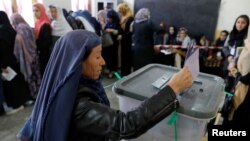 Seorang perempuan Afghan memasukkan suara ke kotak suara dalam pemilihan parlemen di sebuah tempat pemungutan suara di Kabul, Afghanistan, 20 Oktober 2018. 