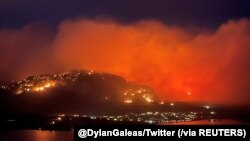 Asap membubung dari api kebakaran hutan tampak di Highway 3 dekat Kota Osoyoos, British Columbia, 20 Juli 2021. (Foto: Twitter @DylanGaleas via Reuters) 
