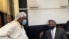 Journalist Hopewell Chin'ono talks to Harrison Nkomo of Zimbabwe Lawyers for Human Rights, in the courthouse at Harare Magistrate’s Court, Jan. 9, 2021. (Columbus Mavhunga/VOA)