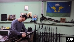 FILE - A member of the Russian Imperial Movement, a nationalist group in Russia, Denis Valliullovich Gariev holds a weapon simulator at a training base in Saint-Petersburg, Feb. 28, 2015.
