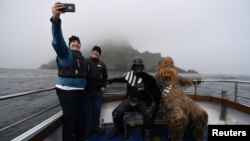 Holidaymakers take a selfie, along with Star Wars fans dressed in costume as Darth Vader and Chewbacca, on a boat trip to Skellig Island during the inaugural "May The 4th Be With You" festival in the County Kerry village of Portmagee, Ireland, May 4, 2018