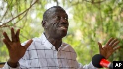 FILE - Opposition leader and presidential candidate Kizza Besigye speaks to the media while under continued house arrest, at his home in Kasangati, outside Kampala, Feb. 21, 2016. A Ugandan judge freed Kizza Besigye on bail Tuesday, rejecting prosecutors' calls for him to be remanded indefinitely until his case is concluded.