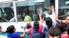 Un grupo de mujeres intentan hablar con familiares que están siendo trasladados a una prisión por policías durante el estado de emergencia, según el Ministerio de Justicia y Seguridad Pública, en San Salvador, El Salvador, el 7 de junio. 2022.