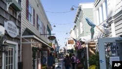 ARCHIVO - Gente camina frente a las tiendas el 13 de noviembre de 2020 en Rehoboth Beach, Delaware, EEUU.