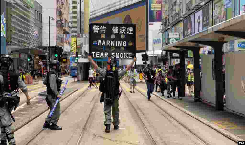 防暴警察5月24日下午在銅鑼灣軒尼斯道高舉黑旗,警告將會施放催淚煙驅散反惡法遊行的群眾。(美國之音湯惠芸拍攝)