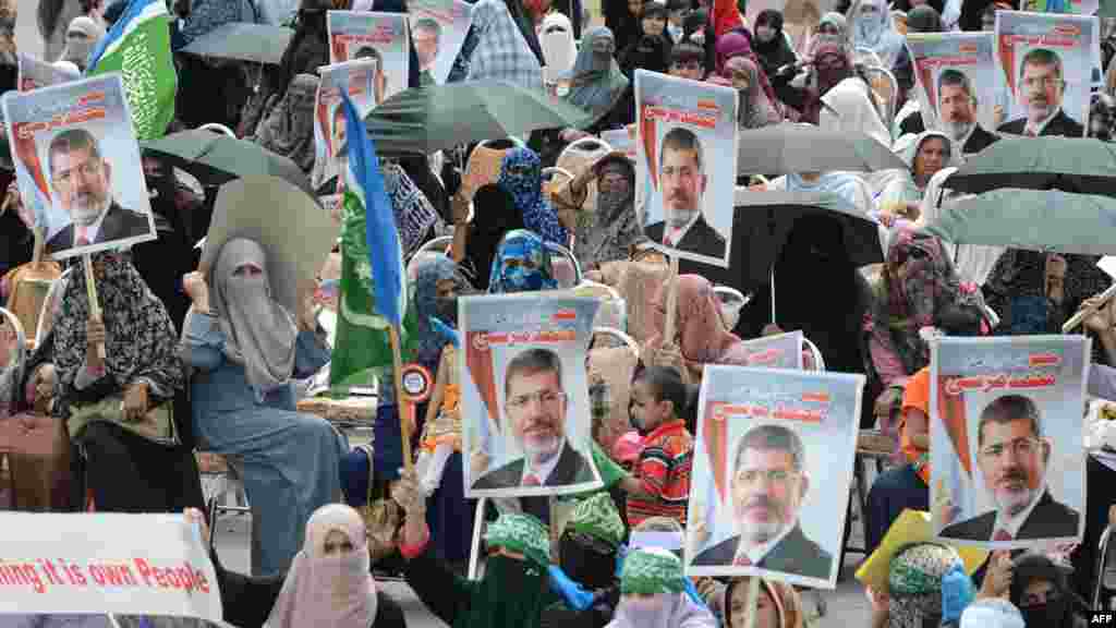 Women activists of Islamic political party Jamaat-e-Islami (JI) hold pictures of ousted Egyptian president Mohamed Morsi during a pro-Morsi rally in Islamabad on August 18, 2013.