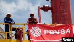 ARCHIVO - Trabajadores petroleros en una plataforma petrolera operada por la empresa estatal venezolana PDVSA, en Morichal, en julio de 2011.