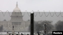 Miembros de la Guardia Nacional custodian el Capitolio en Washington, DC., tras una cerca protectora el 31 de enero de 2021.