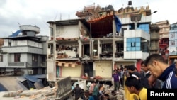 Warga melihat-lihat lokasi bangunan yang hancur akibat gempa di Kathmandu, Nepal (25/4). (Reuters/Navesh Chitrakar)