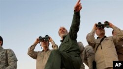 FILE - A photo by the government-controlled Syrian Central Military Media, shows Iran's Army Chief of Staff Maj. Gen. Mohammad Bagheri, left, and other senior officers on the front line in the northern province of Aleppo, Syria, Oct. 20, 2017.