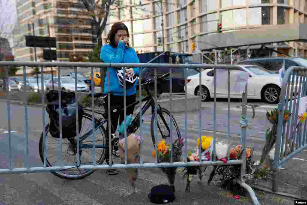 Kate Anstett, 22, wipes tears from her eyes by a makeshift memorial for victims of Tuesday's attack outside a police barricade on the bike path next to West Street in New York City, Nov. 1, 2017.