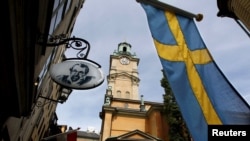 Le drapeau suédois flotteant près de la cathédrale de Stockholm. Septembre 2010