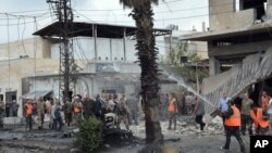 Dalam foto yang dirilis oleh kantor berita resmi Suriah, SANA, pasukan keamanan Suriah dan para petugas pemadam kebakaran berkumpul di lokasi ledakan bom di pusat Kota Homs, Suriah, Selasa, 23 Mei 2017.
