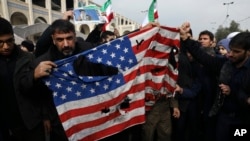 Demonstranti cepaju američku zastavu na protestu zbog vazdušnog udara u Iraku u kome je ubijen general Revolucionarne garde Kasem Sulejmani u Teheranu, 3. januara 2020.