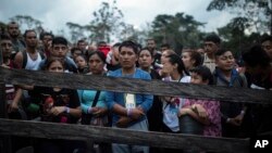 ARCHIVO - Migrantes que planean comenzar a caminar a través del Tapón del Darién desde Colombia a Panamá con la esperanza de llegar a Estados Unidos se reúnen en el campamento inicial del sendero en Acandí, Colombia, el 9 de mayo de 2023.