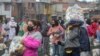 Los residentes se distancian socialmente en un campo de fútbol mientras están parados con bolsas de comida donadas por la ONG local "G10 Favelas", en el área de Capao Redondo de Sao Paulo, Brasil, el lunes 26 de abril de 2021.