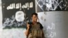 A member of Iraqi counterterrorism forces stands guard near Islamic State militant graffiti in Fallujah, Iraq, June 27, 2016.