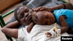 Karina Joseph, de 19 años, consuela a su hijo de 2 años, Netherlands Sineus, mientras recibe tratamiento para el cólera en una tienda de campaña en un hospital de Médicos Sin Fronteras en Cite Soleil, una comuna densamente poblada de Puerto Príncipe, Haití.