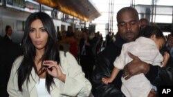 Kim Kardashian bersama Kanye West dan putri mereka North di bandara LAX di Los Angeles, AS, April lalu.