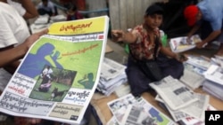 A man shows a People's Age private journal featuring an article written by Burmese pro-democracy leader Aung San Suu Kyi at a market in Rangoon, September 6, 2011.