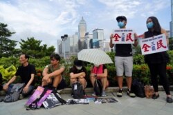 Protesters hold placards reading "Strike for Hong Kong" during continuing pro-democracy rallies in the semi-autonomous Chinese territory, in Tamar Park, Hong Kong, Sept. 3, 2019.