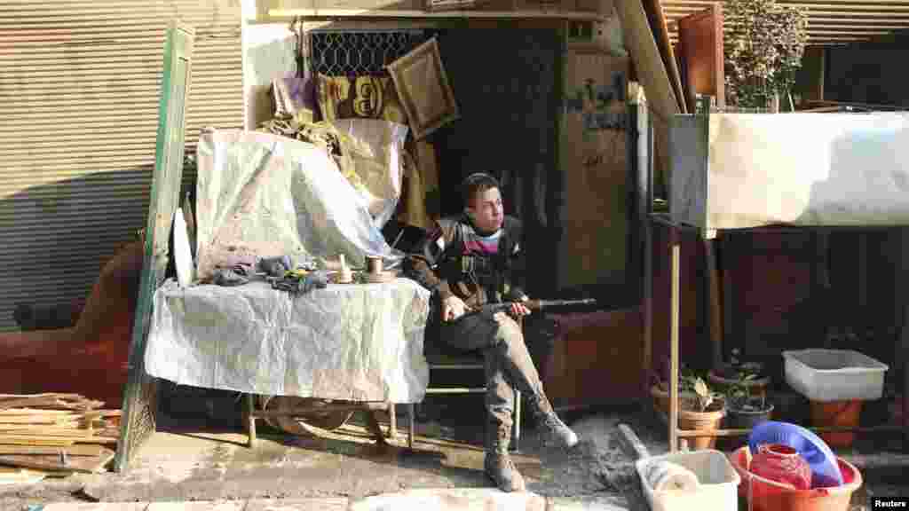 A Free Syrian Army fighter rests with his weapon in the Sheikh Maqsoud neighborhood of Aleppo, Feb. 16, 2014. 