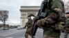 French soldiers cross the Champs Elysees avenue passing the Arc de Triomphe in Paris, Nov. 16, 2015.
