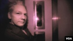 Julian Assange terlihat di dalam mobil polisi saat tiba di Pengadilan Westminster, London, untuk sidang Selasa, 14 Desember 2010.