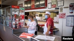 Trabajadores de un restaurante de El Paso, Texas, cumplen las restricciones por el coronavirus el 15 de noviembre de 2020.