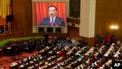 Chinese Premier Li Keqiang is displayed on a huge screen as he delivers a work report at the opening session of the annual National People's Congress at Beijing's Great Hall of the People, March 5, 2017.