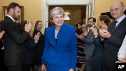 Perdana Menteri Inggris Theresa May disambut oleh staf saat ia kembali ke Downing Street, setelah meminta izin dari Ratu Elizabeth untuk membentuk pemerintahan baru, di London, 9 Juni 2017.