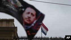 A banner with a picture of Turkish President Recep Tayyip Erdogan, is waved by protesters outside the Dutch consulate in Istanbul, March 12, 2017.