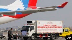 Sebuah van diparkir di dekat pesawat untuk mengangkut vaksin produksi AstraZeneca / Universitas Oxford yang diproduksi di bawah lisensi Serum Institute of India, di Bandara Internasional Tribhuwan di Kathmandu, Nepal, Kamis, 21 Januari 2021. (AP Photo/Niranjan Shrestha)