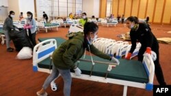 Members of the Cambodian military prepare beds for COVID-19 patients at a wedding party hall in Koh Pich that is being turned into field hospital in Phnom Penh on Apr. 11, 2021.