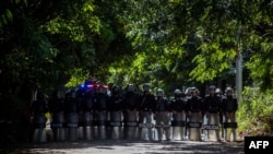 Una fila de antimotines permanece frente a las instalaciones del diario El Confidencial en Managua el 14 de diciembre de 2020. Photo by STR / AFP