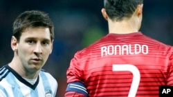 Lionel Messi de l'Argentine à gauche de Cristiano Ronaldo du Portugal avant le coup d’envoi d’un match amical international de football à Old Trafford Stadium, Manchester, en Angleterre, 18 novembre 2014. (AP Photo / Jon Super)