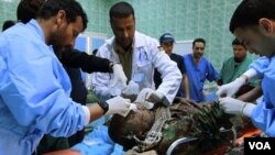 Los equipos médicos aitenden en el hospital de Ajdabiyah a uno de los combatientes heridos.