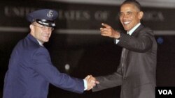 Presiden Barack Obama (kanan) mendengarkan kru media menyanyikan lagu 'Happy Birthday' sesaat setelah ia mendarat di Lapangan Udara Andrews (04/8).