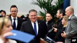 Menteri Luar Negeri Hongaria Peter Szijjarto (tengah) dan Mengeri Luar Negeri AS Mike Pompeo (tengah), tiba untuk menghadiri konferensi pers setelah pertemuan di Budapes, Hongaria, Senin, 11 Februari 2019.