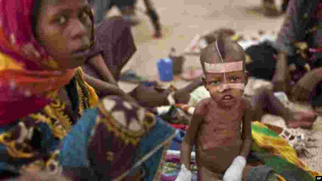 Halime Moussa, 3, reçoit un traitement par un tube d'alimentation nasal et avec les mains bandées pour l'empêcher de retirer, à la salle de nutrition thérapeutique de l'hôpital de la ville, dont sa mère Kaltouma Abakar, à gauche, a voyagé 70 km pour atteindre, à Mao, capitale de la région du Kanem au Tchad, le mardi 17 Avril 2012. (AP Photo / Ben Curtis)